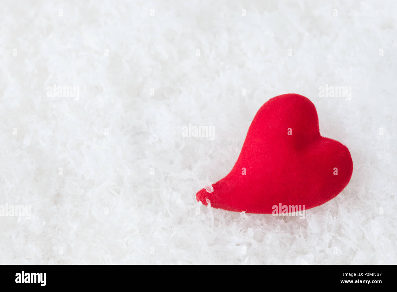 Einzelne rote Herzen liegen auf flauschigen weißen kalten Schnee. Metapher der Liebe erz Einsamkeit. Grußkarten zum Valentinstag Stockfoto