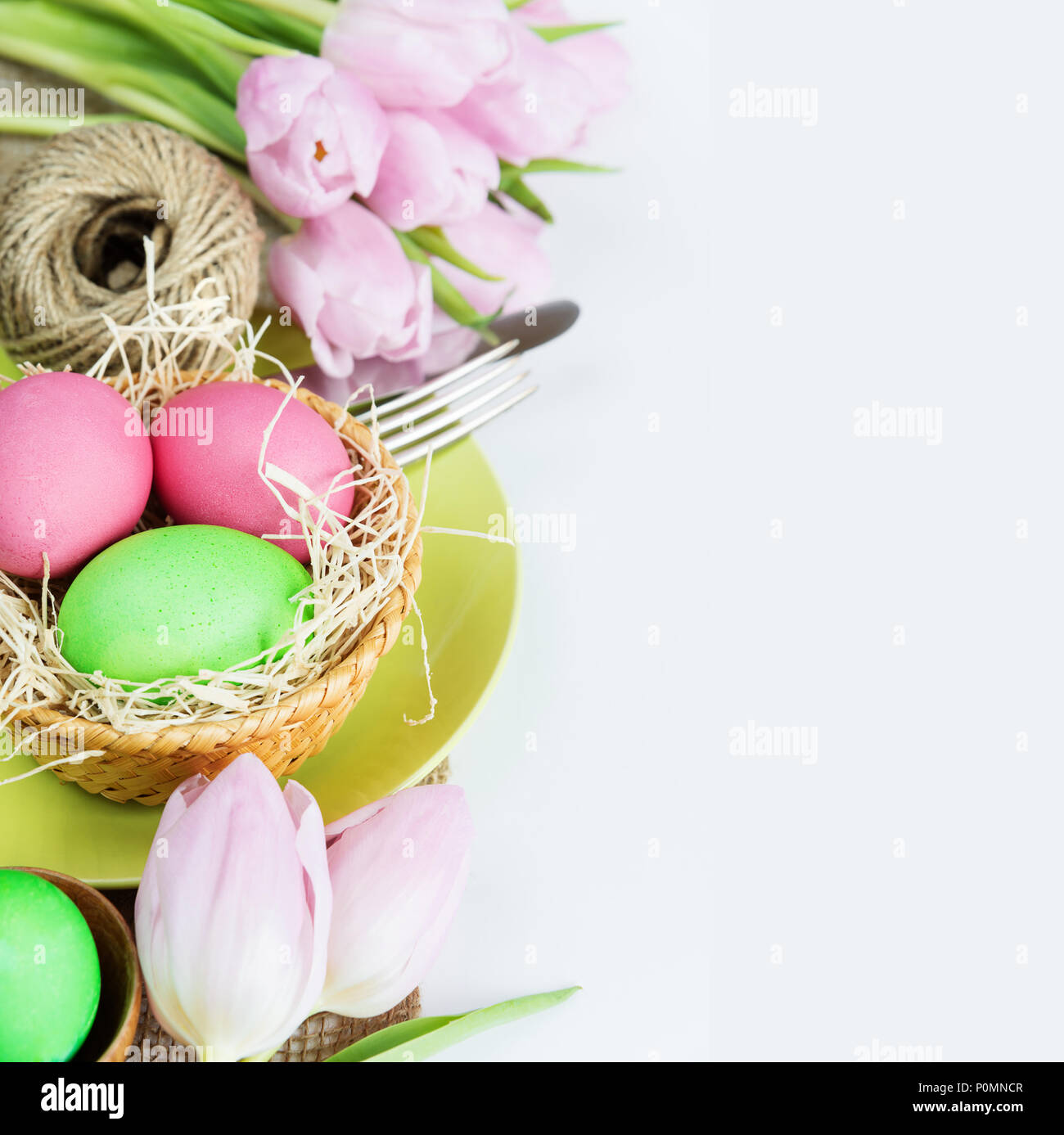 Ostern Zusammensetzung: Bouquet von rosa Tulpen Blumen und Ostern Eier, Teller und Besteck, mit copy-Raum Stockfoto