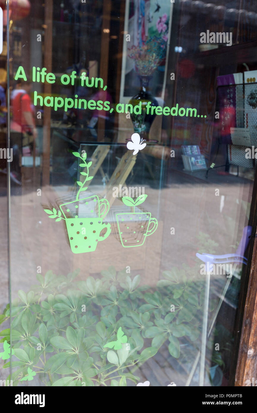 Yangzhou, Jiangsu, China. Dong Guan Straße. Nachricht an einem Schaufenster: Spaß, Glück, Freiheit. Stockfoto