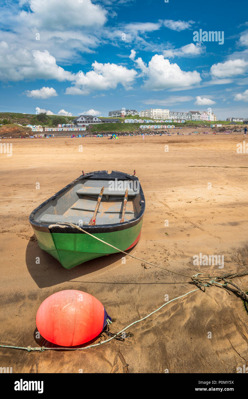 Eine einsame grüne Boot ist Liegeplätze bei Ebbe auf der Schönen und beliebten Sandstrand an der Bude in North Cornwall. Stockfoto