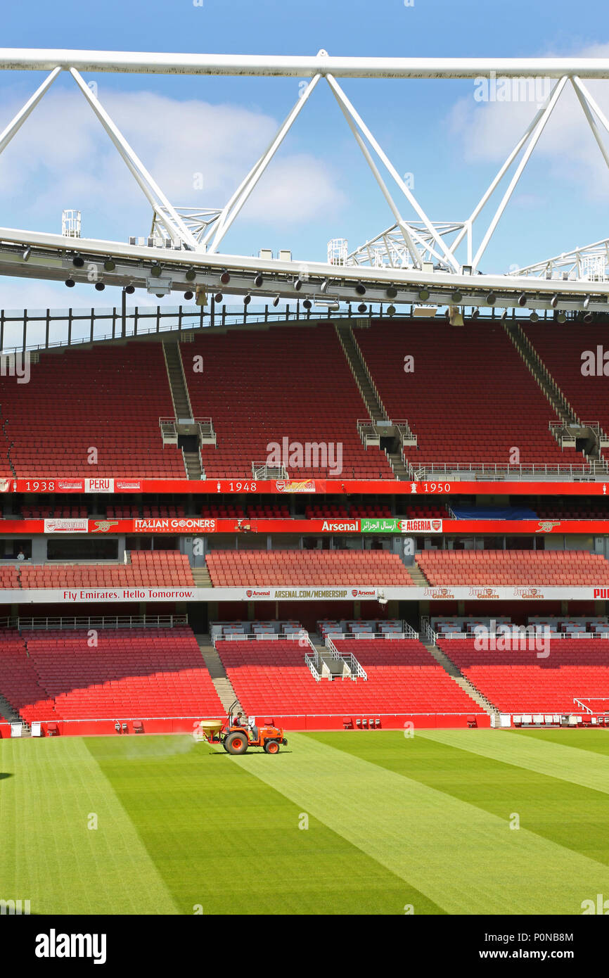 Ein Traktor trimmt das Gras auf dem Spielfeld im Londoner Emirates Stadium, das Heimstadion Erstligisten Arsenal. Stockfoto