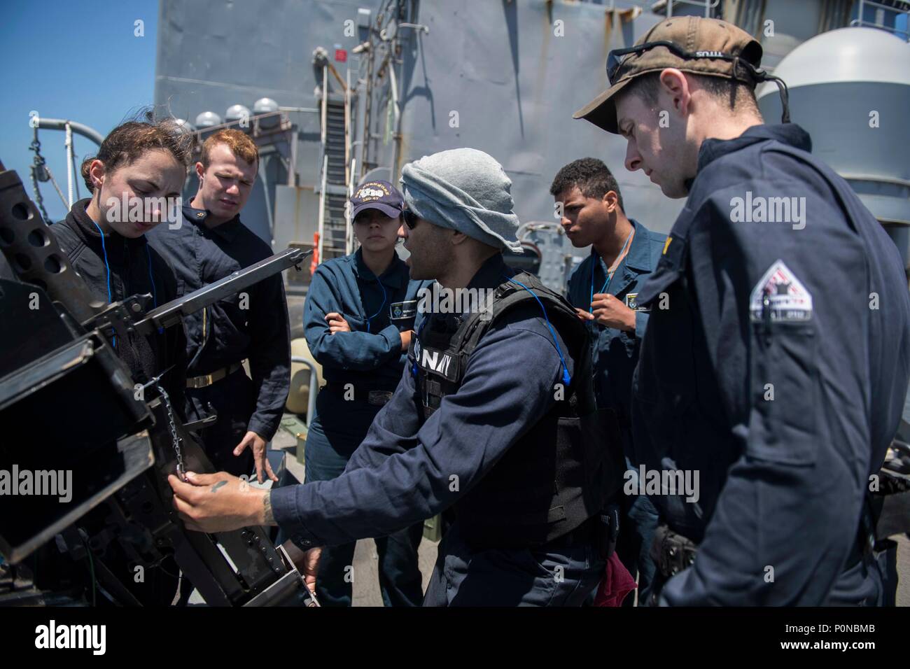 180601-N-GR 847-0026 PAZIFISCHER OZEAN (3. Juni 2018) Die Gunner Mate 1. Klasse Clarence Jones, von San Bernardino, Kalifornien, zeigt, wie ein .50 Kaliber Maschinengewehr zu Matrosen zugewiesen zu Whidbey Island-Klasse dock Landung Schiff USS Rushmore (LSD 47) während einer Composite Trainingsgerät Übung (COMPTUEX). COMPTUEX ist die letzte Übung vor der Bereitstellung, die die kombinierten Essex Amphibious Ready Gruppe und Fähigkeiten 13 Marine Expeditionary Unit der militärischen Operationen auf See und Projekt power zu leiten an Land in der kommenden Einsatz im Sommer 2018 bescheinigt. (U.S. Marine Foto von Masse Comm Stockfoto