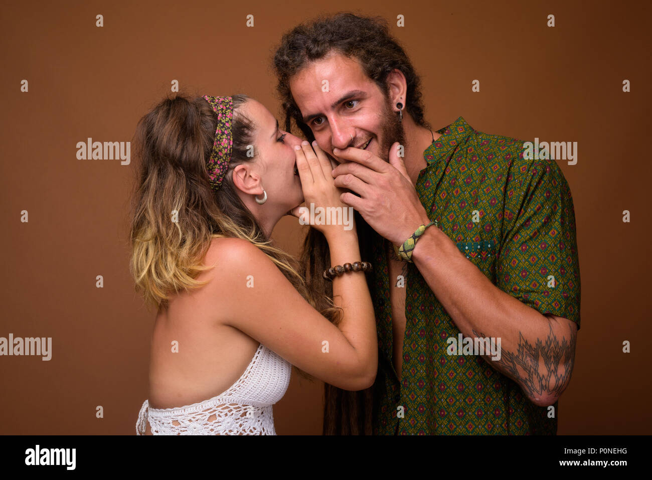 Junge Hispanic Paar zusammen gegen braunen Hintergrund Stockfoto