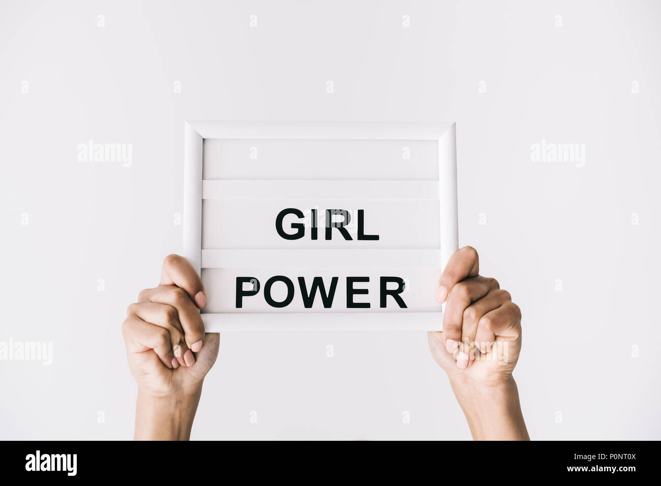 Teilweise mit Blick auf die weibliche Hände halten Platte mit Girl Power isoliert Schriftzug auf Grau Stockfoto