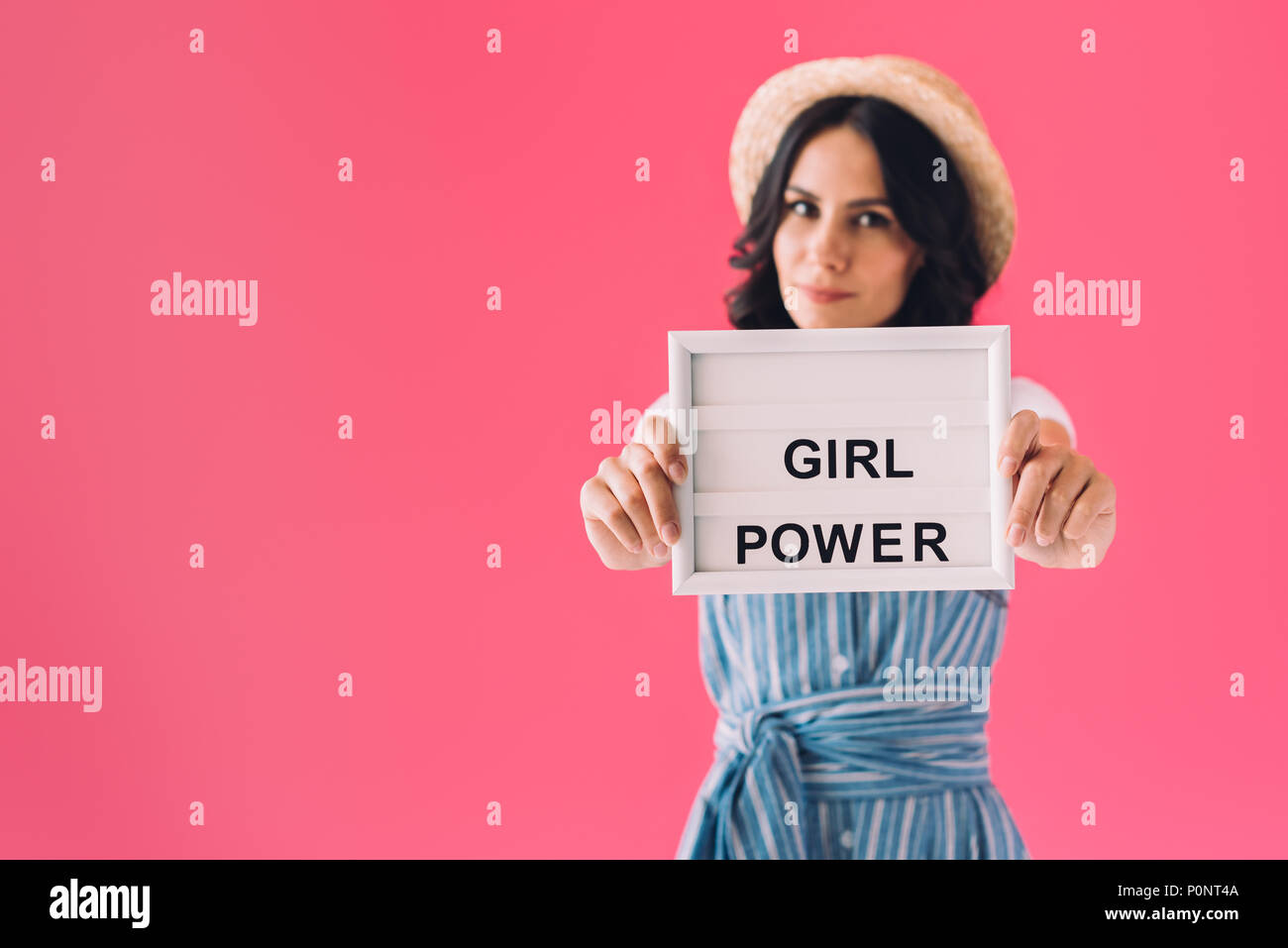 Selektiver Fokus der Frau, Girl Power Board in den Händen isoliert auf Rosa Stockfoto