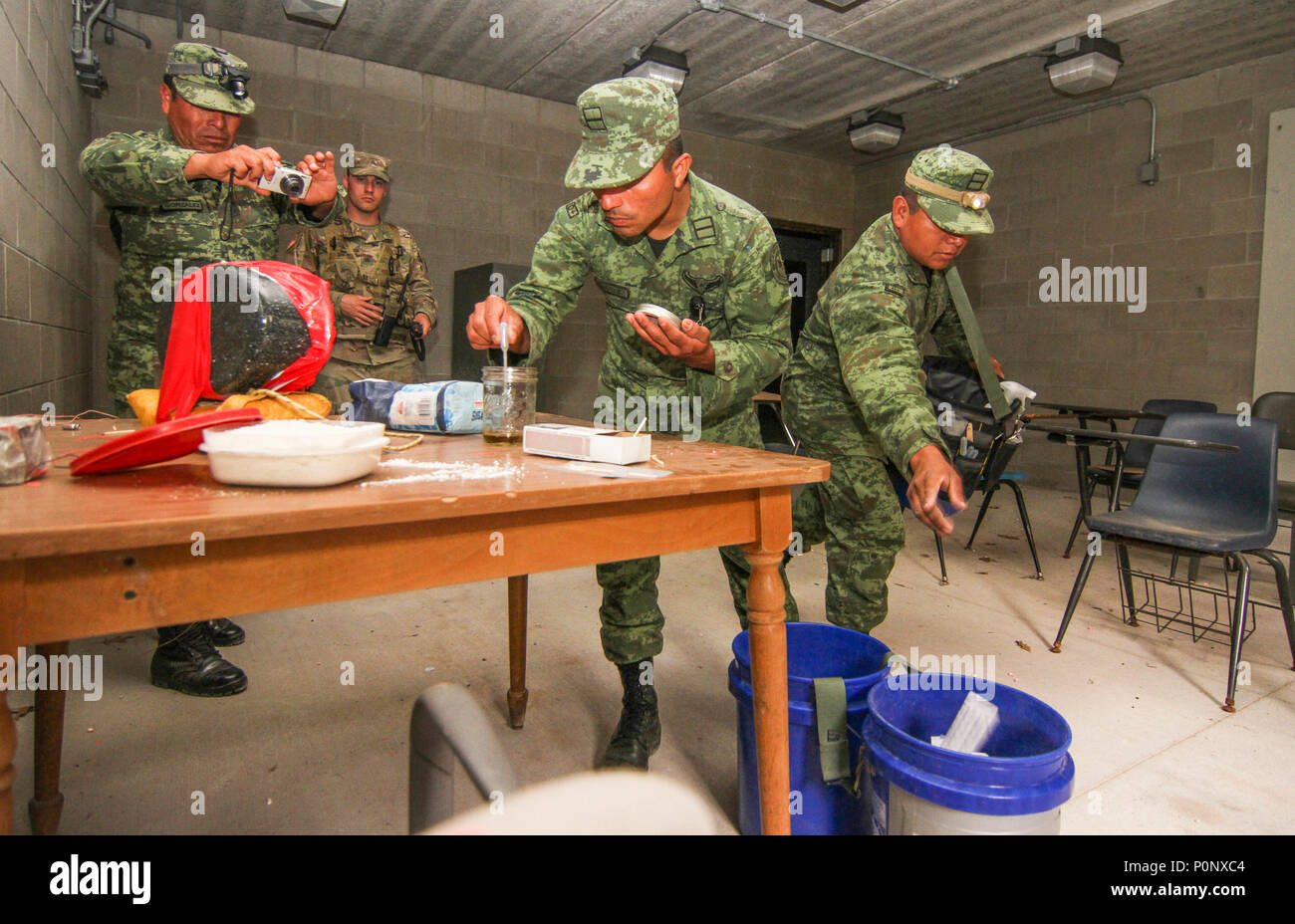 Eine Gruppe der Mexikanischen Armee Soldaten arbeiten zusammen, um zu Fotografieren und Prozess einer vermuteten chemischen Labor als US National Guard Soldaten des 460Th Chemical Company, 210th Military Police Battalion während eines chemischen, biologischen, radiologischen und nuklearen (CBRN) Ausbildung Lane im Camp Äsche, Michigan 6. Juni als Teil der Übung Fuerzas Amigas. Fast 30 mexikanische Armee Soldaten haben die letzten mehrere Tage im Camp verbrachte Äschen beobachten und erhalten praktische Schulung und Erfahrung mit chemischen, biologischen, radiologischen und nuklearen Anlagen und Verfahren als Soldaten aus allen drei Komponenten der US-Armee zusammengeschlossen, um t Stockfoto