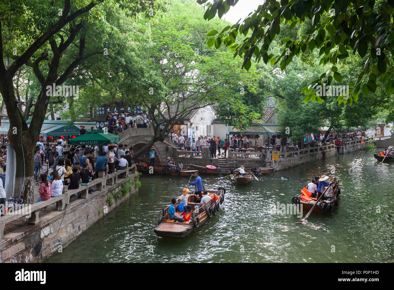 Suzhou, Jiangsu, China. Chinesische Touristen fahren an einem Kanal in der alten Stadt in der Nähe von Suzhou Tongli, einem beliebten Wochenende Reiseziel. Stockfoto