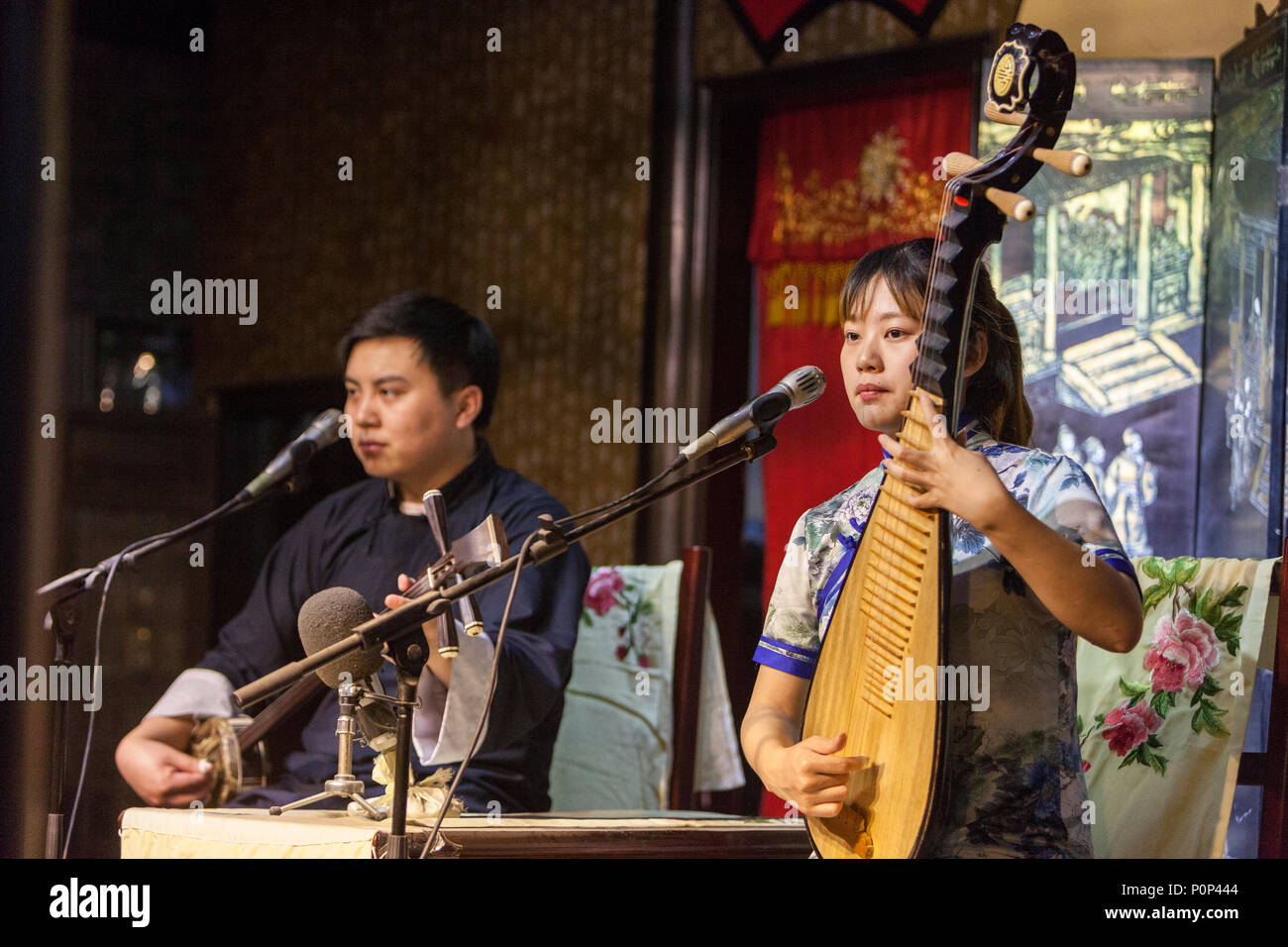 Suzhou, Jiangsu, China. Junge Frau spielt eine Pipa, junge Mann spielt eine "drei Saiten". Stockfoto