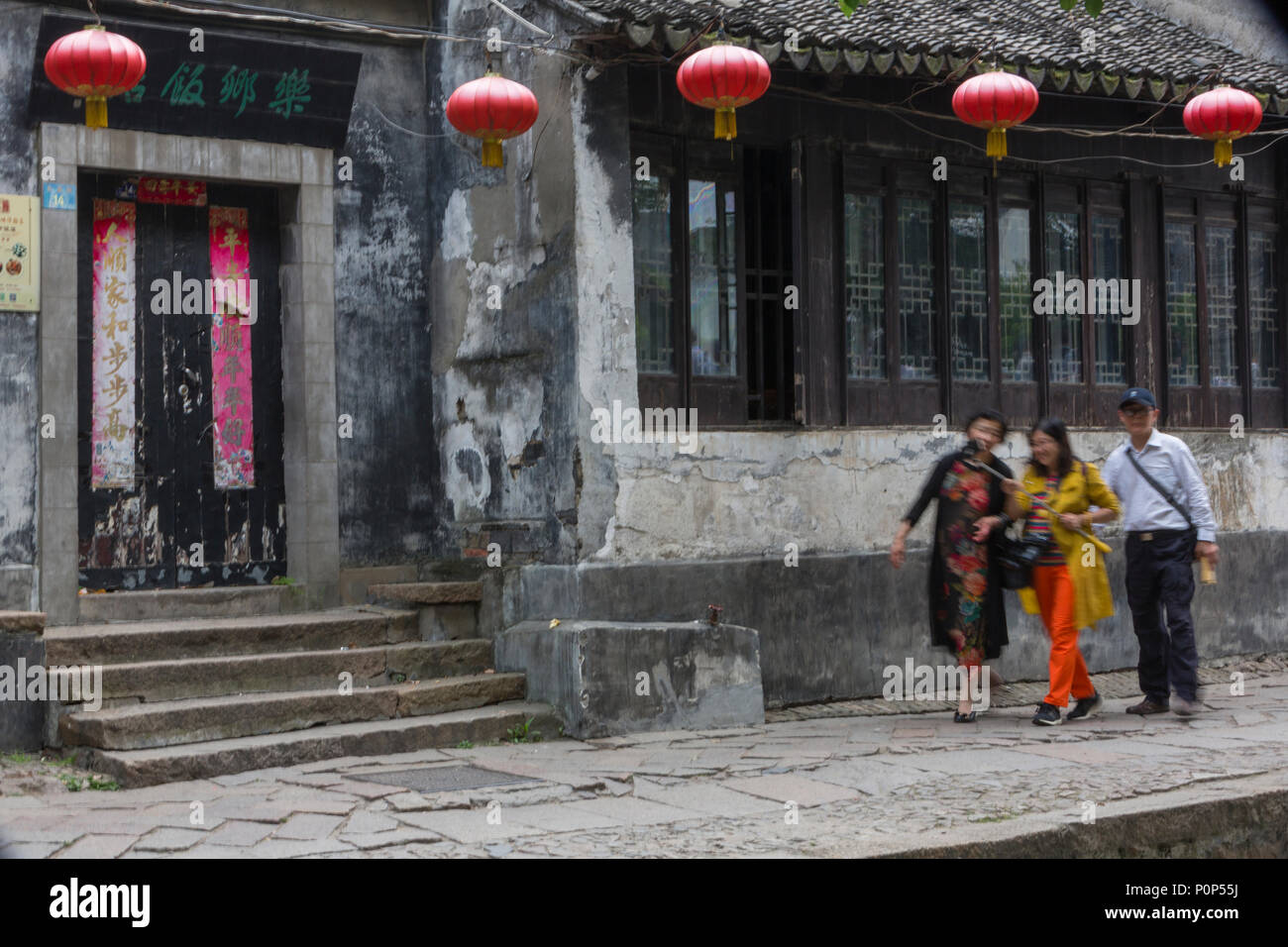 Suzhou, Jiangsu, China. Touristen mit einem selfie Stick eilte auf einem Bürgersteig in Tongli antiken Stadt in der Nähe von Suzhou. Stockfoto