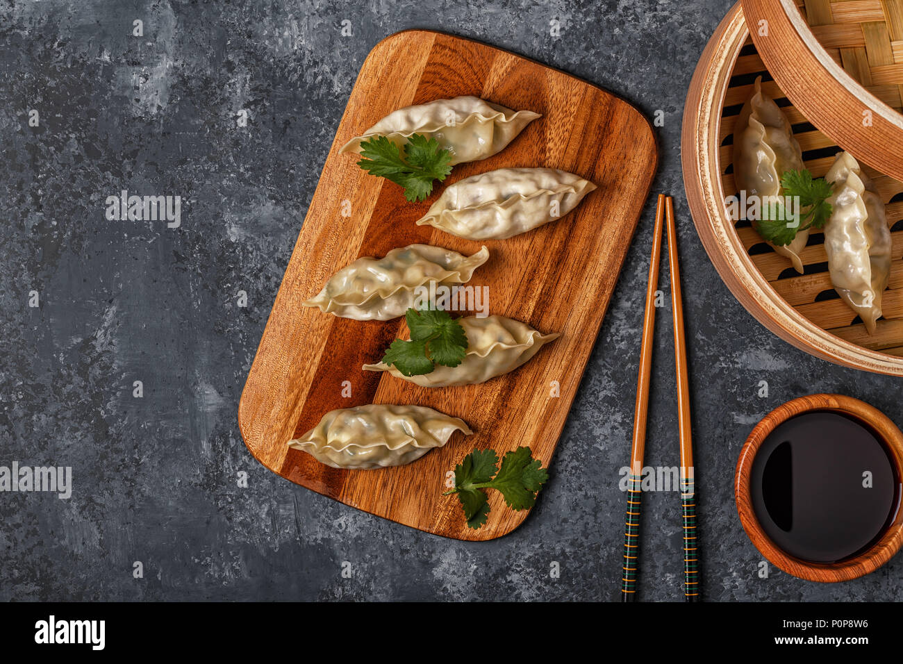 Frische Knödel auf einem dunklen Stein Hintergrund. Asiatische Küche, Ansicht von oben, kopieren. Stockfoto