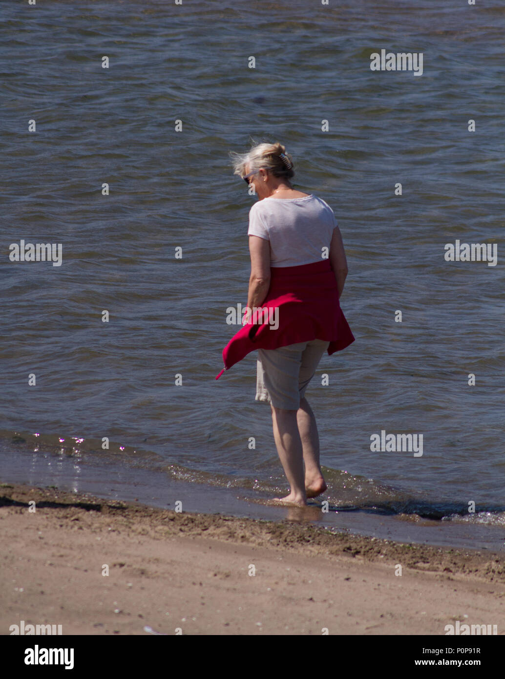 Frau wandern im meer sommer Tag in Ayr, Schottland. Paddeln im Wasser zu kühl bleiben. Stockfoto