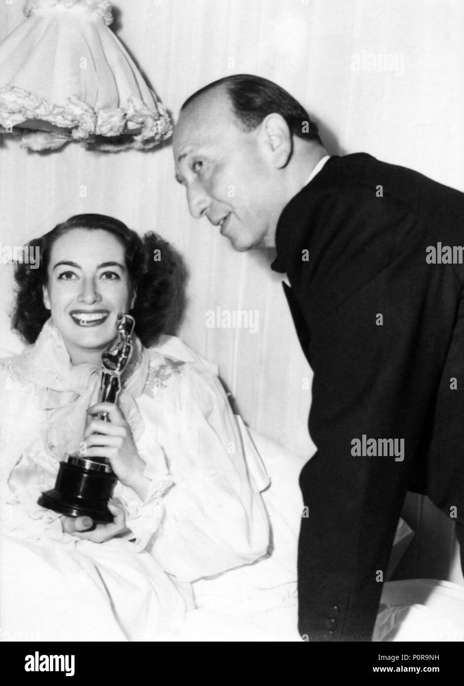 Beschreibung: Die 18. Academy Awards/1946. Michael Curtiz mit Joan Crawford, Sieger der beste Hauptdarstellerin für 'Mildred Pierce'.. Jahr: 1946. Stars: Michael Curtiz; JOAN CRAWFORD. Stockfoto