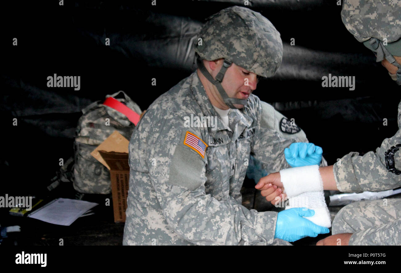 FORT MCCOY, Wisconsin—U.S. Armee Reserve Sgt. John Ludemann, ein Sanitäter mit der 7404th Truppe medizinische Klinik mit Sitz in Cedar Rapids, Iowa, ein Soldat Handgelenk bei Kranken Anruf Eingriffen am 4. Mai 2017 bandagiert. Die 7404th TMC reale medizinische Versorgung vorgesehenen soldatische Durchführung Kampftraining während Krieger Übung 86-17-02 an Fort McCoy, Wisconsin. Eine reale Weltabdeckung kann Mediziner, Hände auf Training und sorgte für Soldaten bekämpfen Übungen in strengen Umgebungen an. Die nachgewiesene Führung, Energie und Ausführung unserer Soldaten gewährleistet. Amerikas Stockfoto