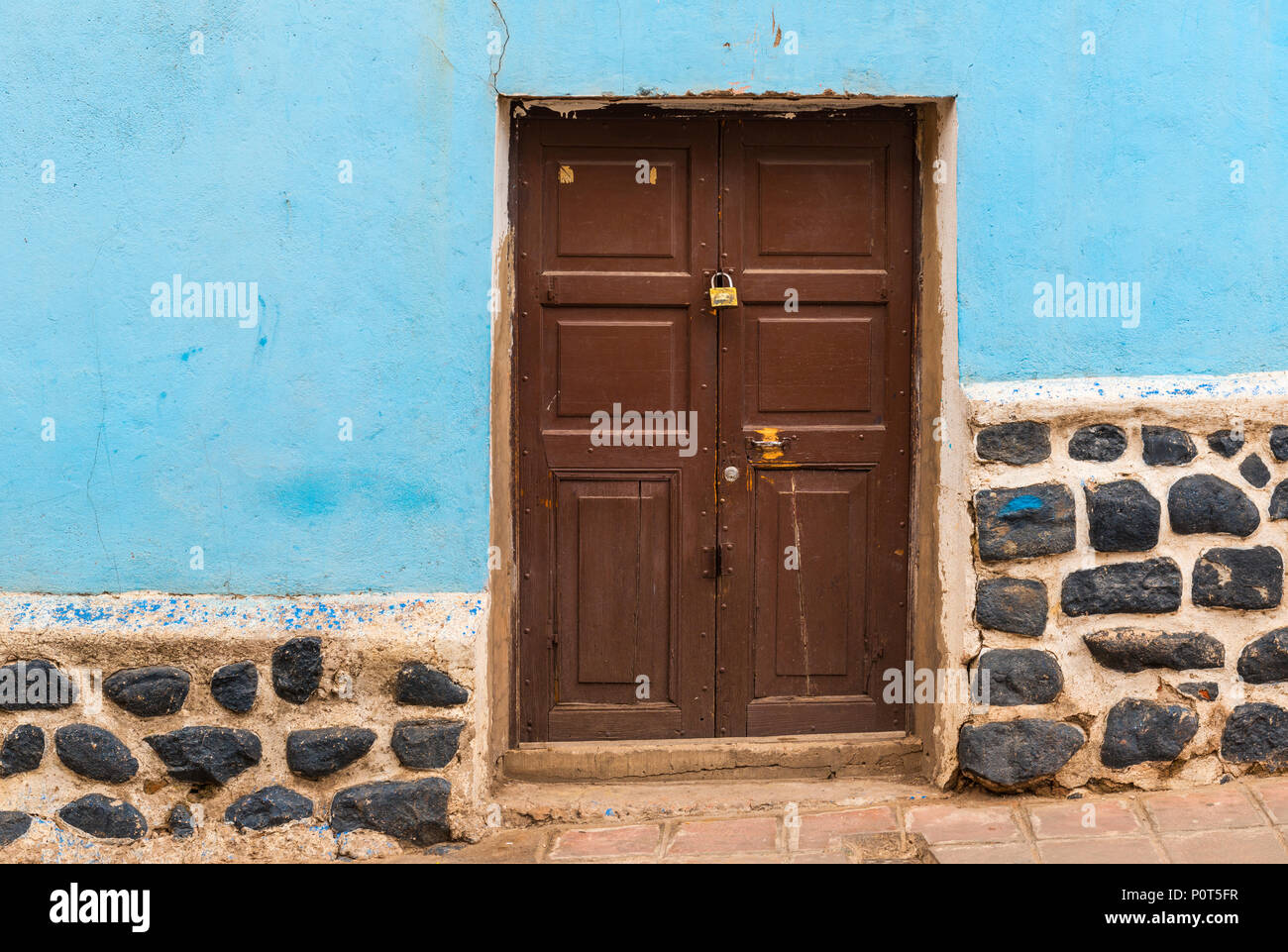 Bunte Fassade mit hölzernen Tür im Zentrum von Potosi (UNESCO Weltnaturerbe), berühmt für die koloniale Architektur, Bolivien. Stockfoto