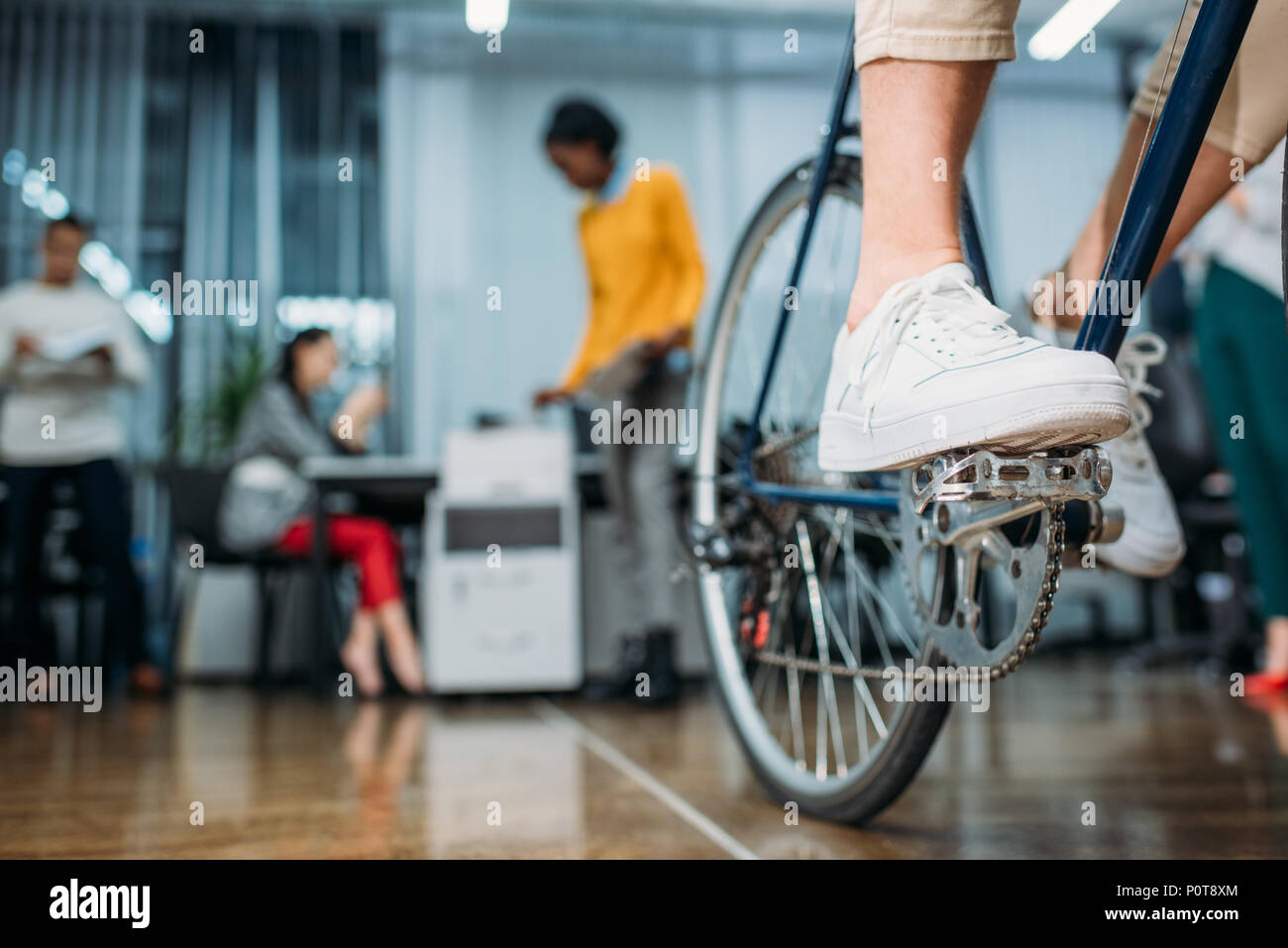 7/8 Schuß von person Reiten Fahrrad an moderne Büro Stockfoto