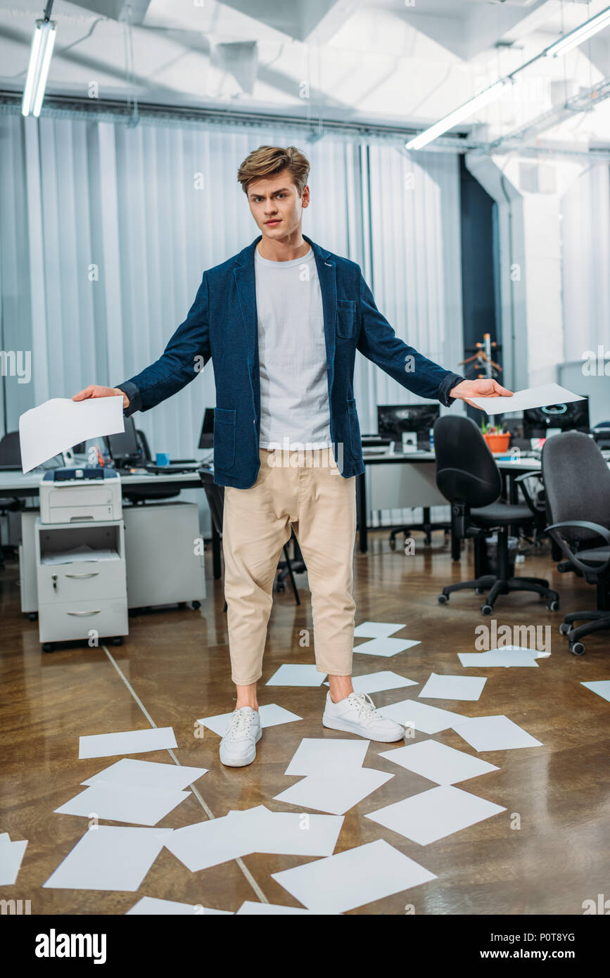 Unternehmer im Büro mit leere Papiere auf dem Boden um ihn herum Stockfoto