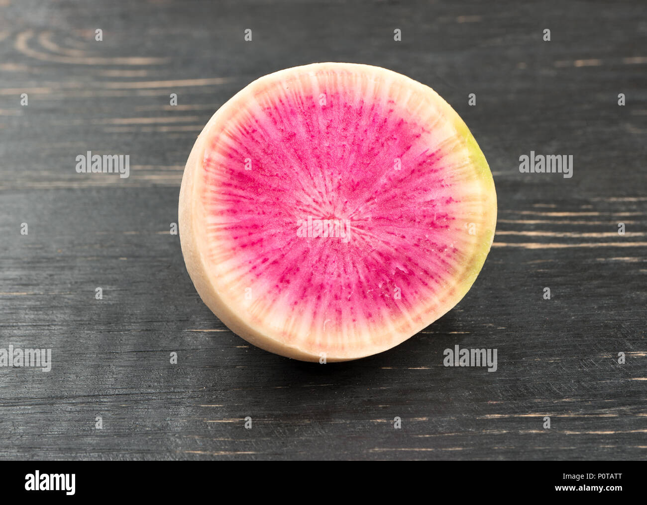 Die Hälfte der saftige Wassermelone Rettich auf dunklen Tabelle Stockfoto