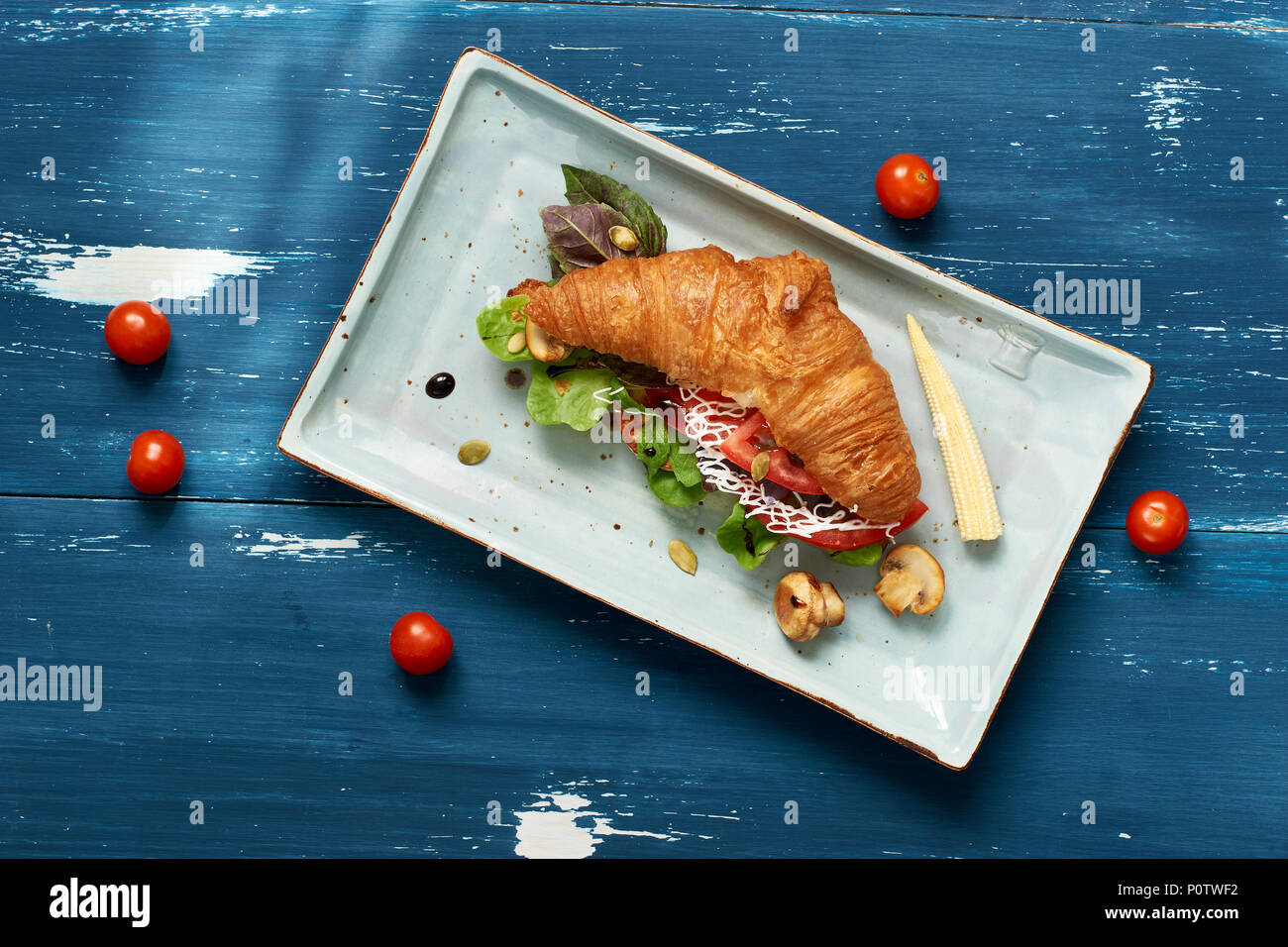 Leckeres Sandwich von Croissant mit Gemüse gefüllt Stockfoto