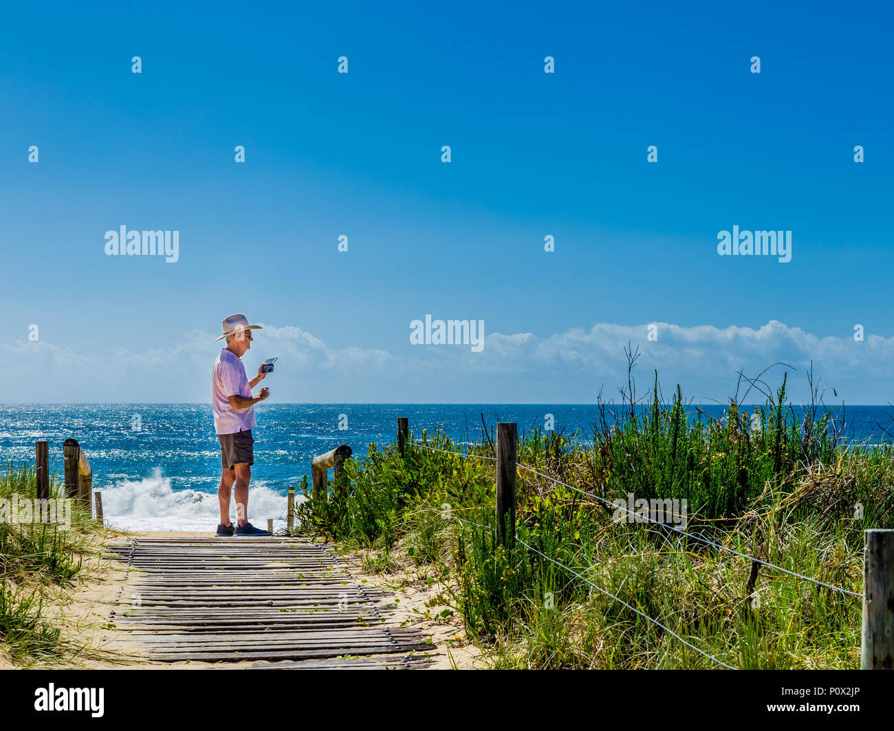 Ma n ein Foto mit seinem Handy auf Zenith Beach, Port Stephens, NSW, Australien Stockfoto