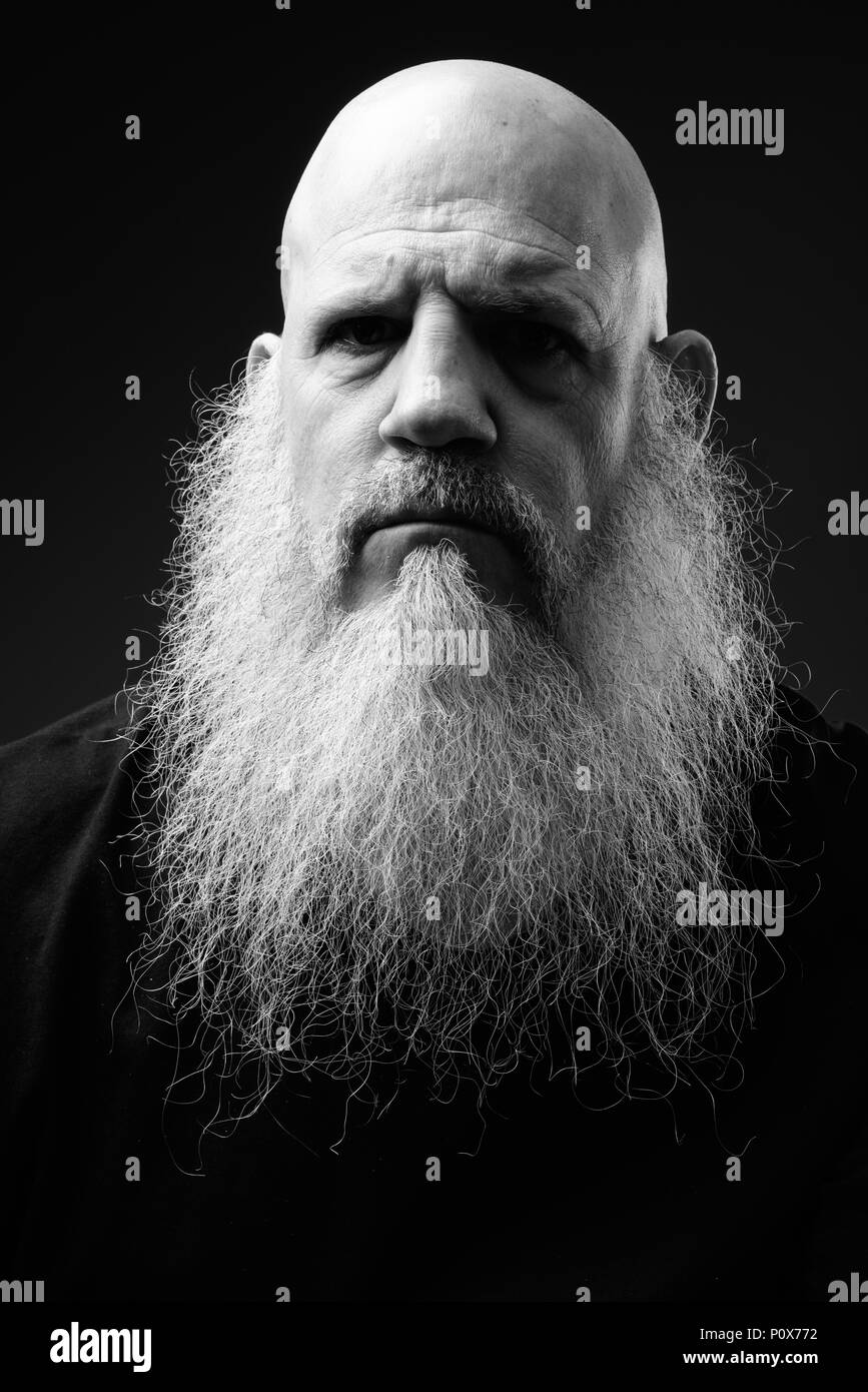 Schwarz-weiß-Porträt zur Reife der glatzköpfige Mann mit langem Bart Stockfoto