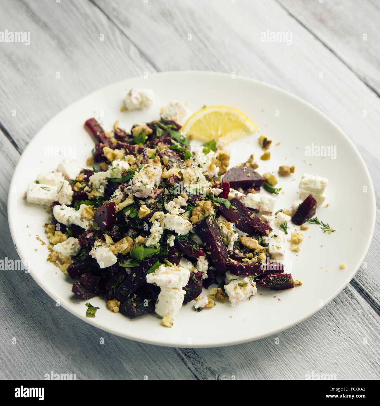 Rote-bete-Salat mit Hüttenkäse und Walnüsse. Europäische Küche. Ökologische Lebensmittel. Vegetarische Vorspeise. Einfache Beilage. Getönten Foto. Stockfoto