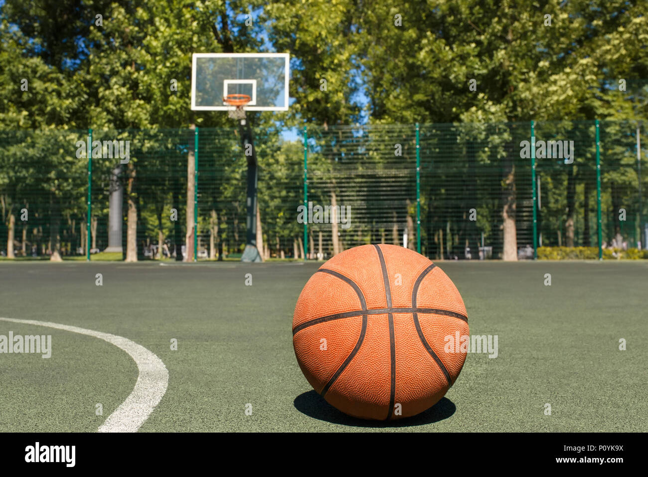 Basketball Ball auf dem freien Gericht mit Hoop auf dem Hintergrund Stockfoto