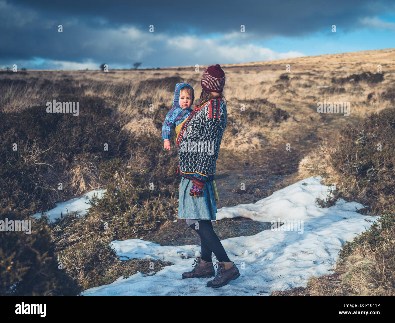 Eine junge Mutter steht in der schmelzende Schnee an einem Moor Stockfoto