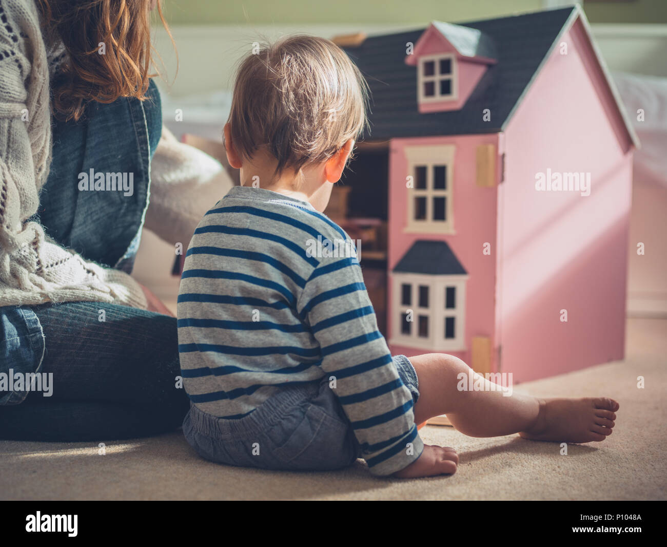 Eine Mutter und ihr Sohn spielen mit einer Puppenstube Stockfoto