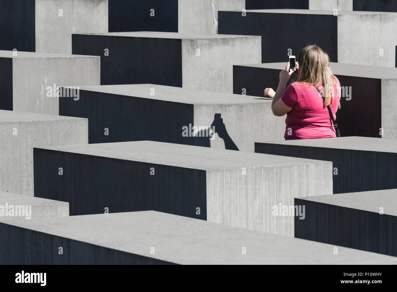 Zwei blonde Frauen mit Smartphones Fotos im Holocaust Denkmal für die ermordeten Juden in Berlin, Deutschland Stockfoto