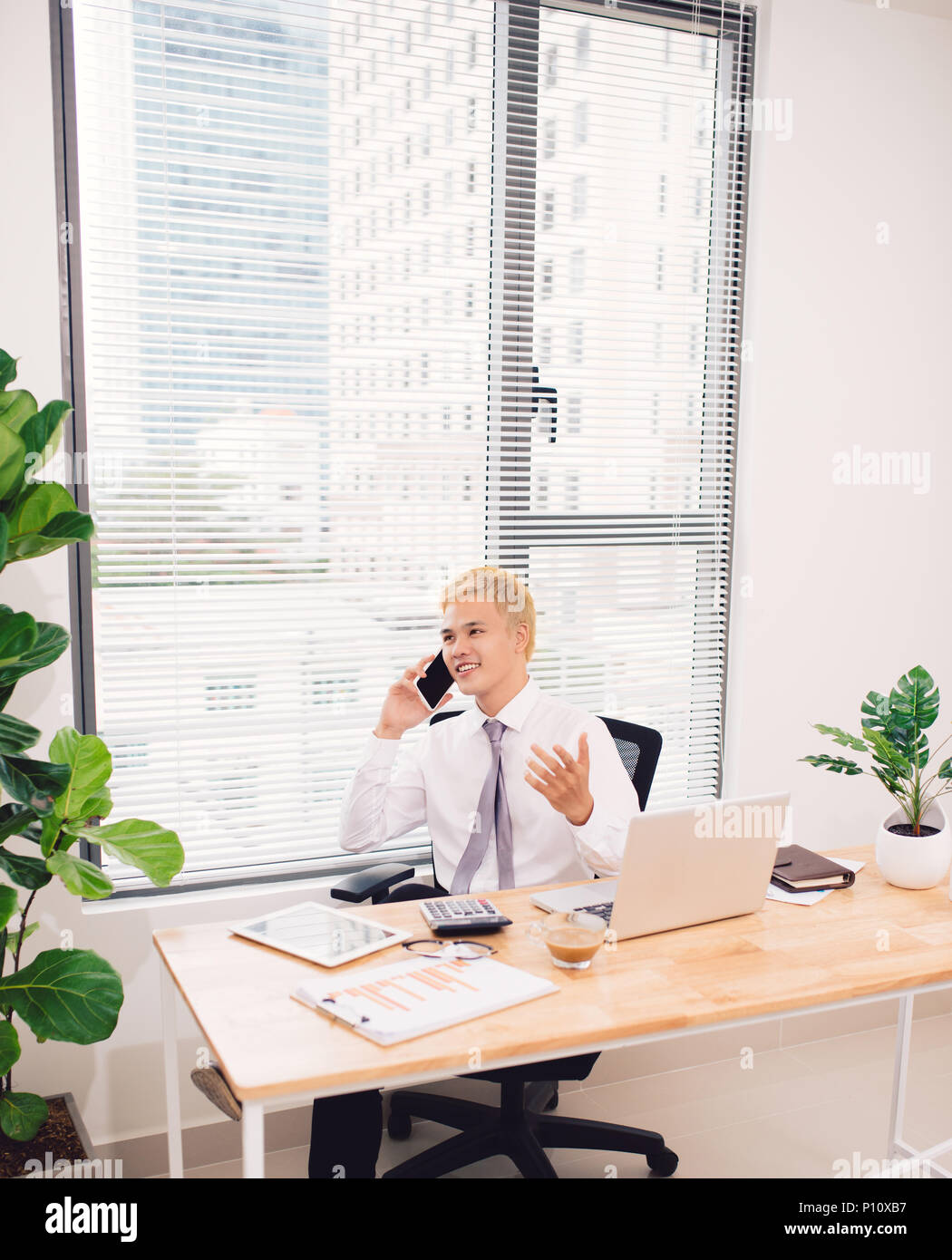 Glücklich Kaufmann am Telefon im Büro Stockfoto