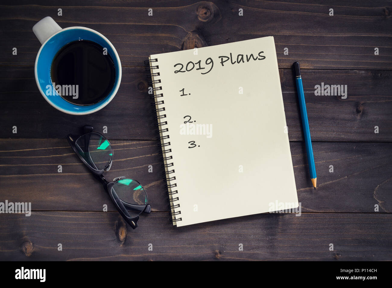 Notebook mit 2019 Eichel Massage, Bleistift, Gläser und Tasse Kaffee auf Holz Hintergrund. Stockfoto