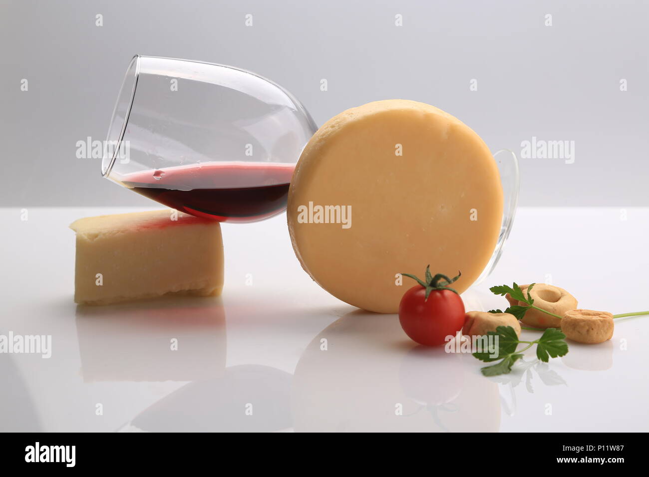Kleiner Käse Rad neben Kirschtomaten Stockfoto