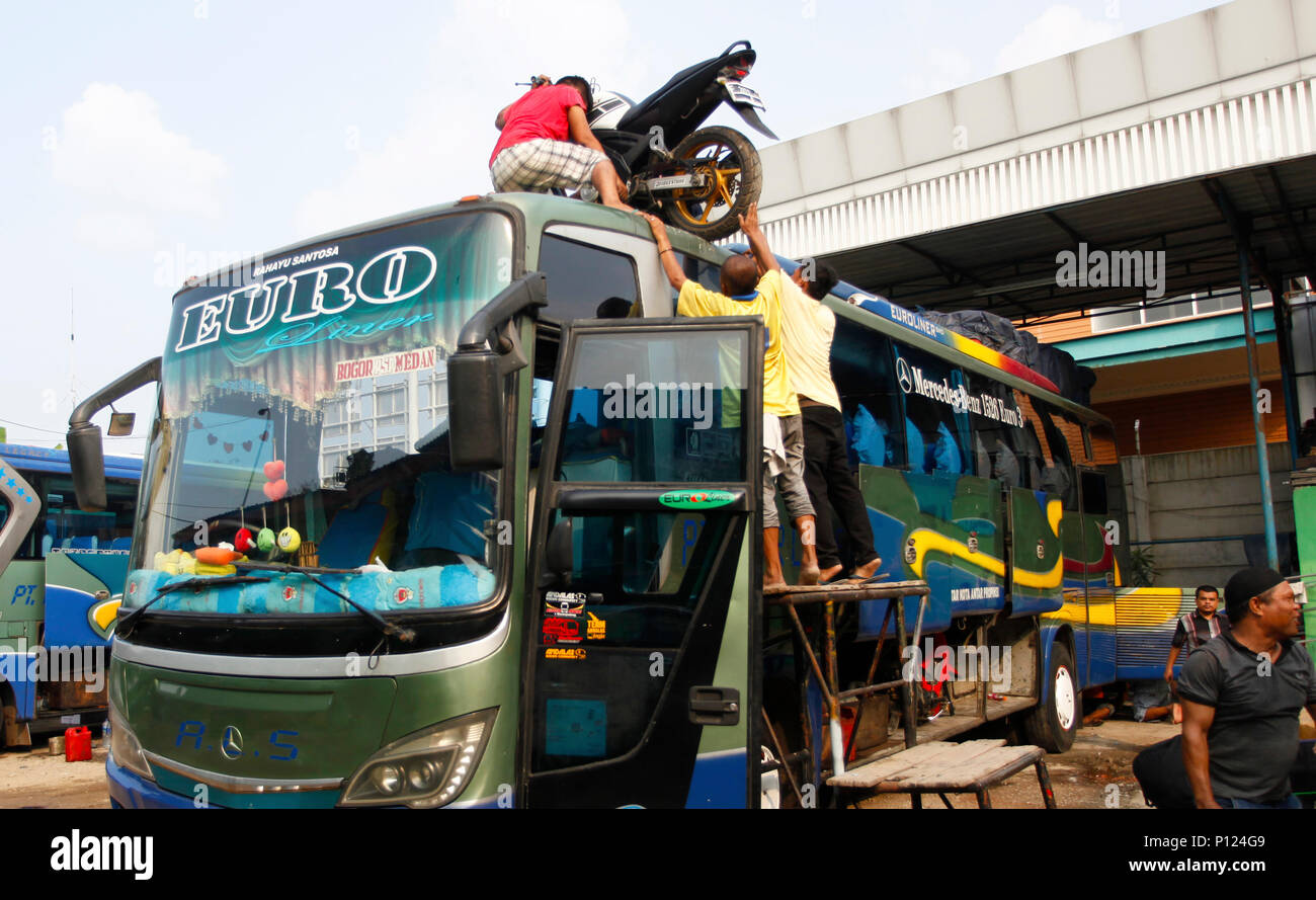 West Java, Indonesien. 9. Juni 2018. Crew bus Aufzüge Motorrad auf dem Dach am Pool von Intercity Kreuz (Antar Lintas Sumatra) ALS, Bogor, West Java, Indonesien. In Richtung des Eid al-Fitr, indonesischen Muslime die Tradition der "udik' Reise zum Dorf durchführen, Treffen mit der Familie. (Foto von Adriana Adinandra/Pacific Press) Quelle: PACIFIC PRESS/Alamy leben Nachrichten Stockfoto