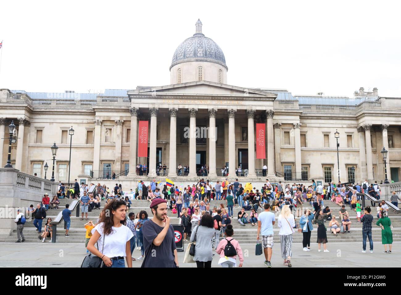 Die Menschen genießen das sonnige Wetter am Trafalgar Square, London, UK Stockfoto