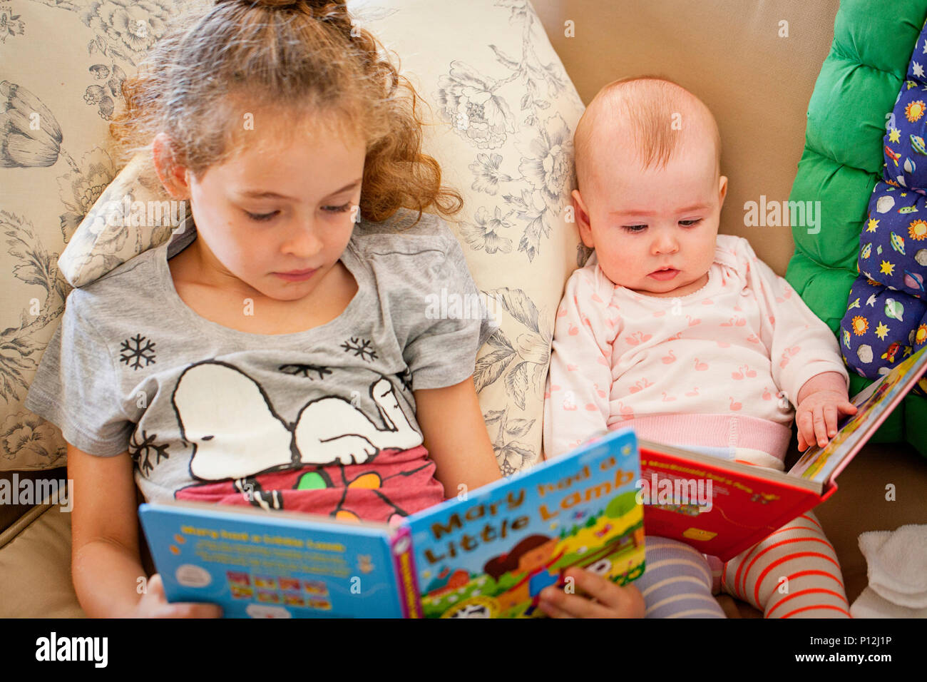 Sechs Jahre altes Mädchen lesen auf ihr Baby cousin Stockfoto