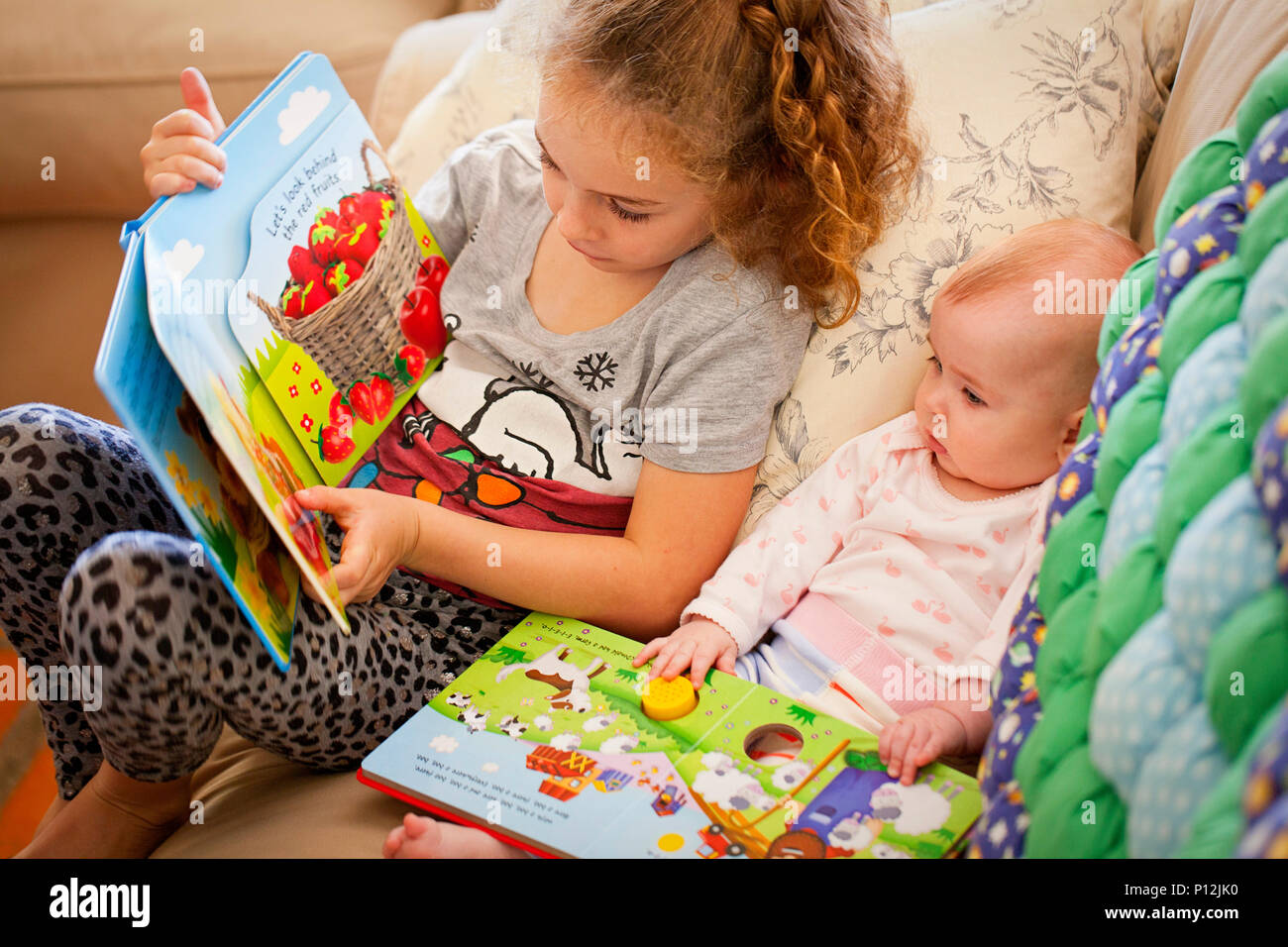 Sechs Jahre altes Mädchen lesen auf ihr Baby cousin Stockfoto