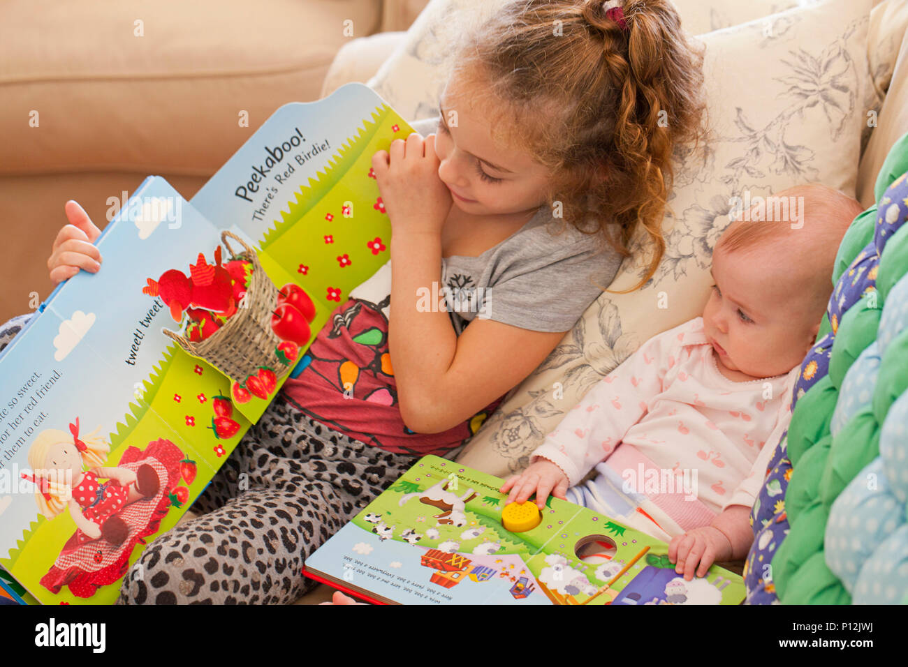 Sechs Jahre altes Mädchen lesen auf ihr Baby cousin Stockfoto