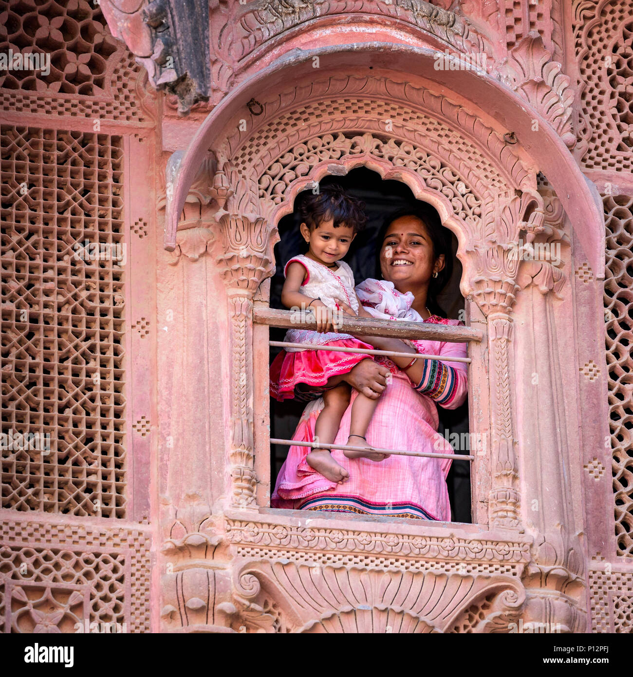 Mutter mit Kind durch ein Fenster von Mehrangarh Fort, Meherangarh, Jodhpur, Rajasthan, Indien Stockfoto