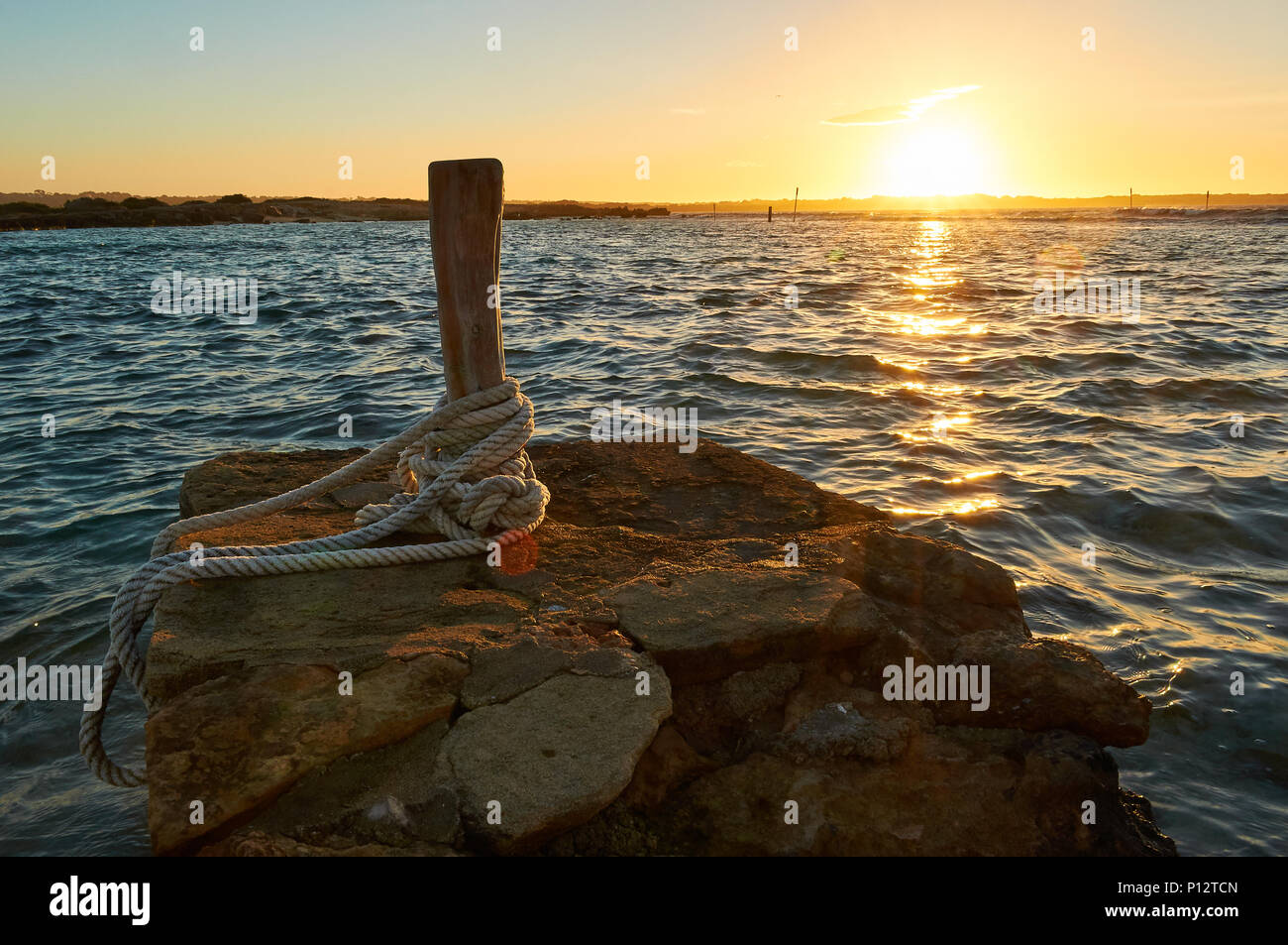 Traditionelle Verankerung Poller bei Sonnenuntergang am Eingang des Estany des Peix Lagune in Ses Salines Naturpark (Formentera, Balearen, Spanien) Stockfoto