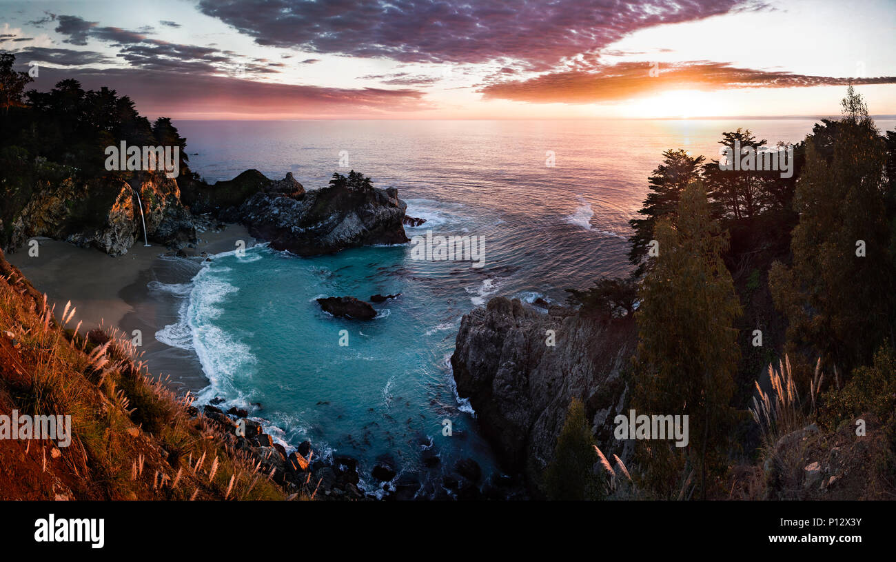 Sonnenuntergang mit Strand, Bucht, Wald und Wasserfall. McWay Falls, Big Sur, Kalifornien Stockfoto