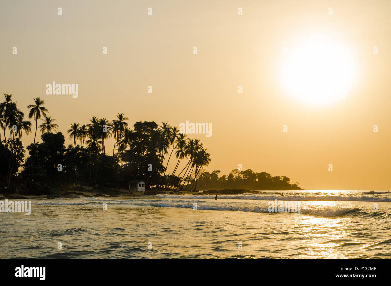 Schöne Bureh Strand bei Sonnenuntergang mit Schattenrissen von Palmen und Surfer, Sierra Leone, Afrika Stockfoto