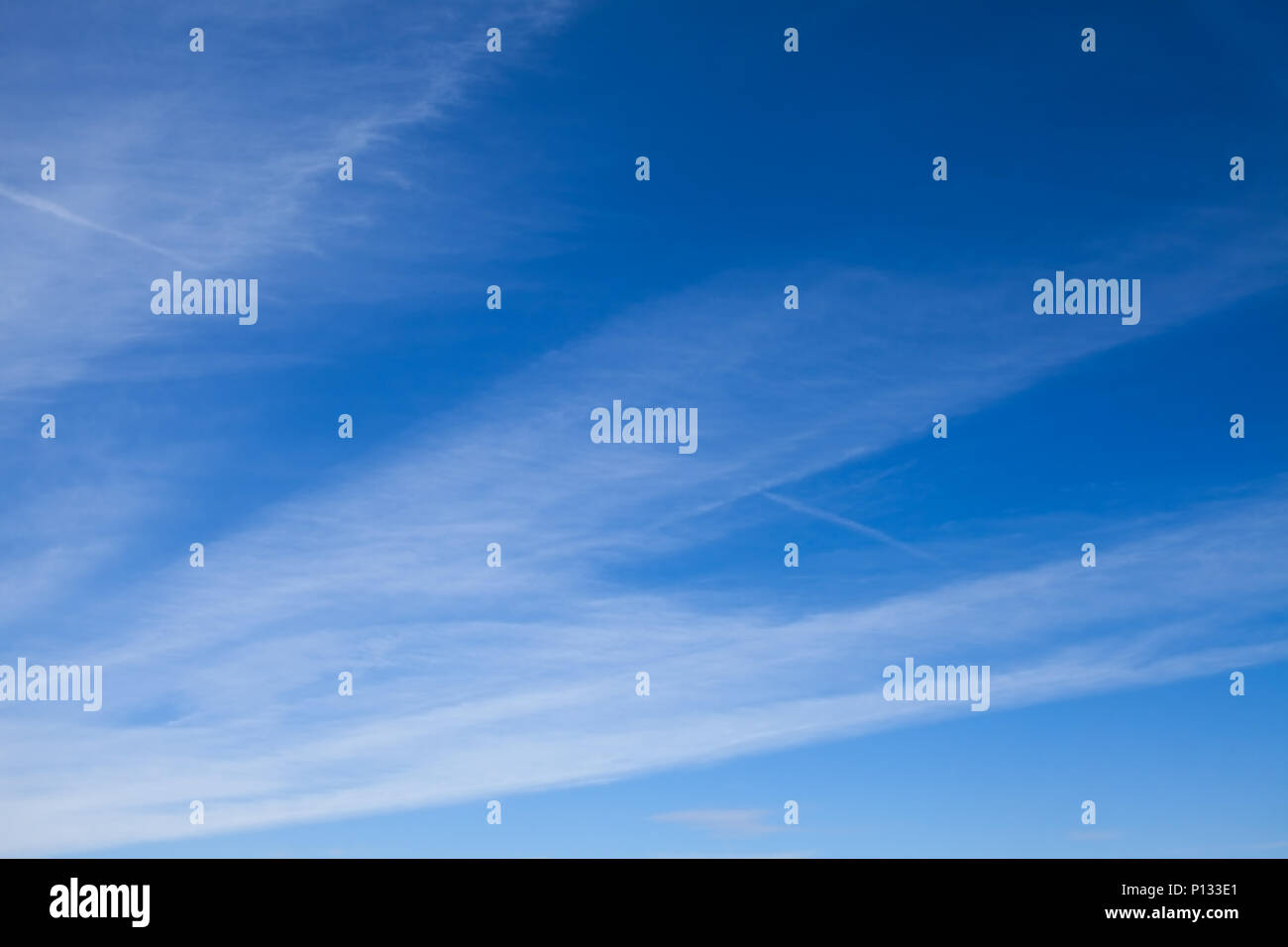 Blauer Himmel mit gestreifte Wolken. Kondensstreifen. Stockfoto