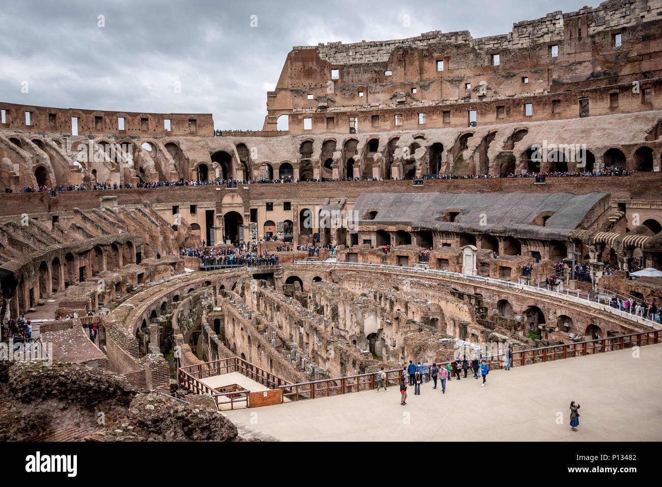 Rom Kolosseum oder zum Kolosseum (Colosseo) Übersicht, uncrowded Innenraum, wenig Touristen, grau bewölkter Himmel tagsüber, Moody kühlen Tönen, außerhalb der Saison im Inneren. Stockfoto