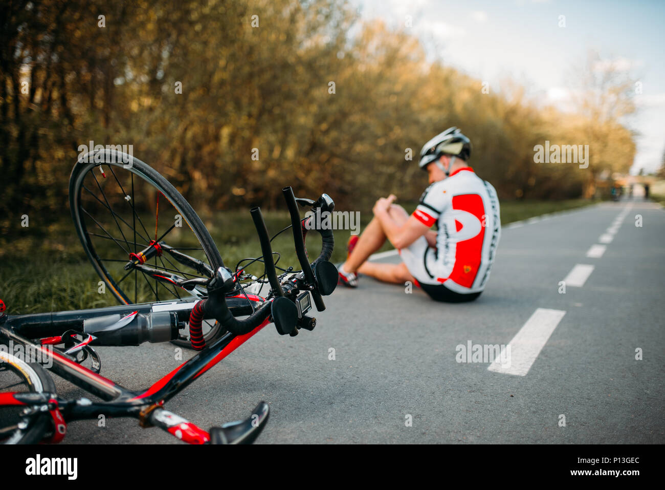 Männliche bycyclist fiel aus Fahrrad und schlug seine Knie, Radfahren auf Radweg Stockfoto