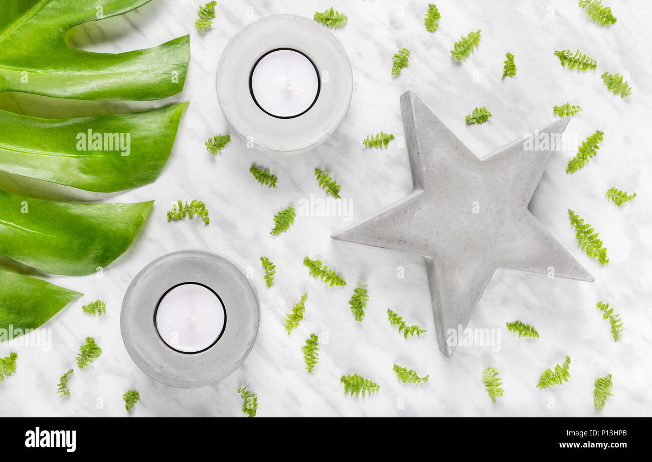 Grüne Blätter, konkrete Star und Kerzenhalter auf Marmor Hintergrund. Flach Komposition. Stockfoto