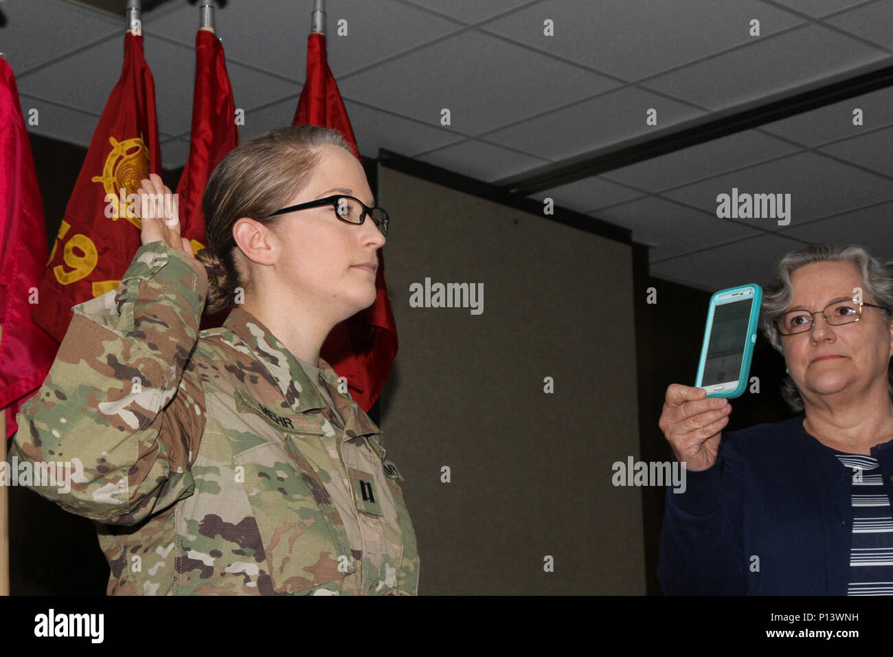 Kapitän Sarah Mehr, ein Transport Offizier mit seiner 632 Bewegung Control Team, 129 Bekämpfung Sustainment Support Bataillons, Luftlandedivision Sustainment Brigade, 101 Abn. Div., nimmt den Amtseid, 5. Mai 2017, während ihrer Promotion Zeremonie an die 129 CSSB Hauptquartier in Fort Campbell, Ky. Kapitän James Mehr, Sarah's Bruder, der derzeit in Afghanistan mit der US-Armee Korps der Ingenieure transatlantischen Afghanistan Bezirk eingesetzt, wird der Eid über das Telefon während der Zeremonie verwaltet. Stockfoto