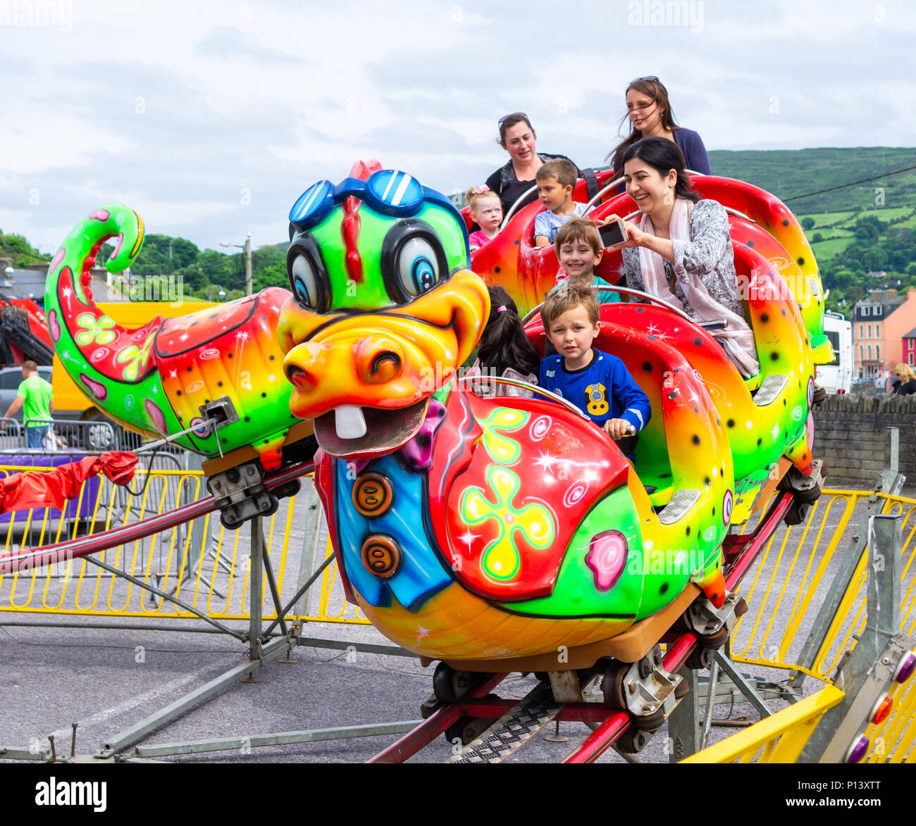 Familie genießen Sie einen vergnüglichen Tag auf die Fahrgeschäfte auf der Kirmes in Bantry, Irland. Stockfoto