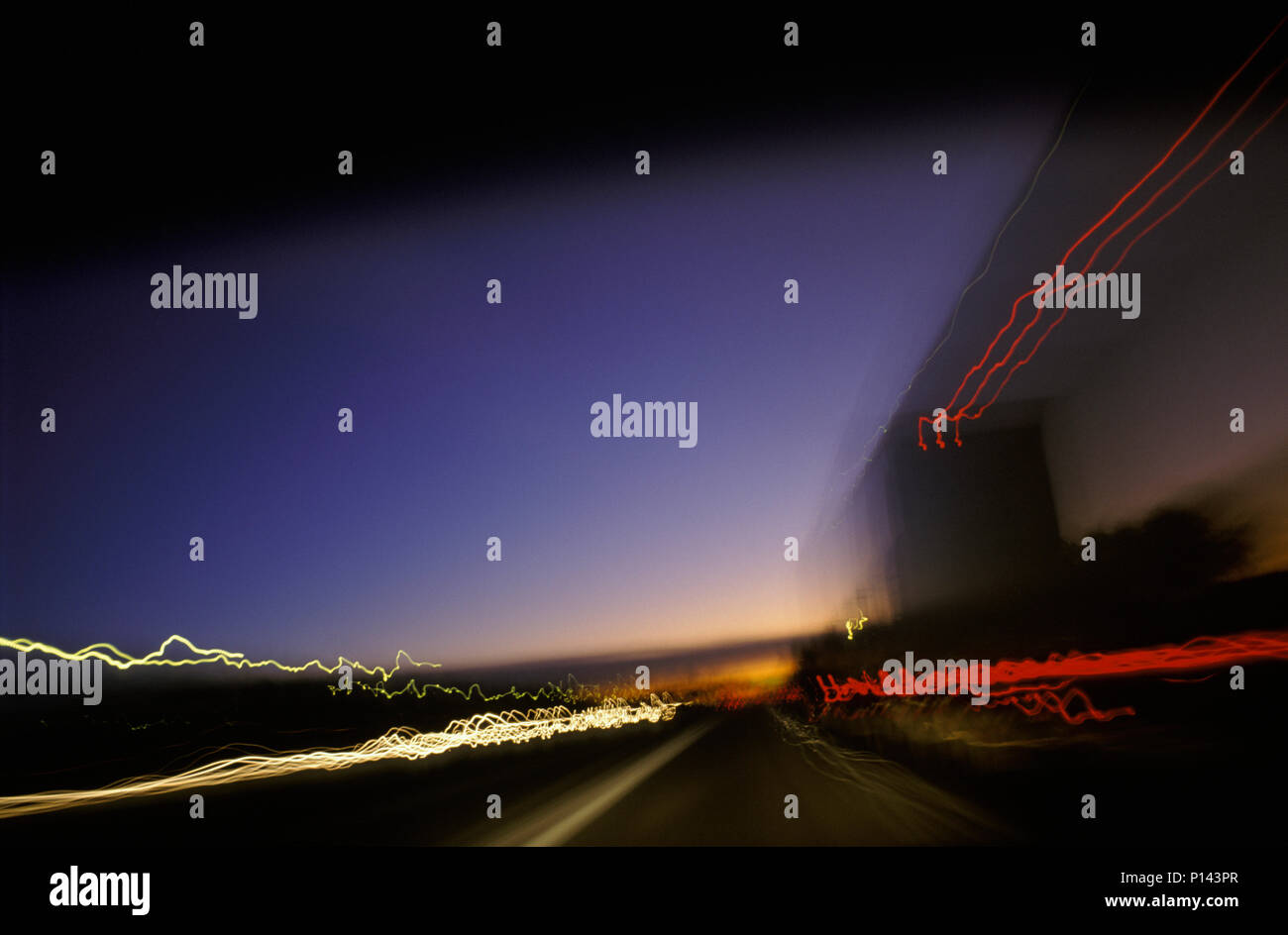 Traktor - Trailer gesehen, die auf einer Autobahn in der Dämmerung mit Streifen von Licht und Leuchten im Horizont, in der Nähe von Phoenix, AZ, USA Stockfoto