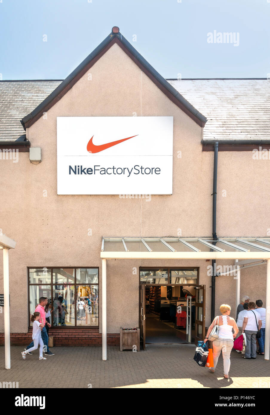 Käufer außerhalb der Nike Factory Store in Gretna Gateway Outlet Village, eine Reise Mall' ganz im Süden von Schottland. Stockfoto