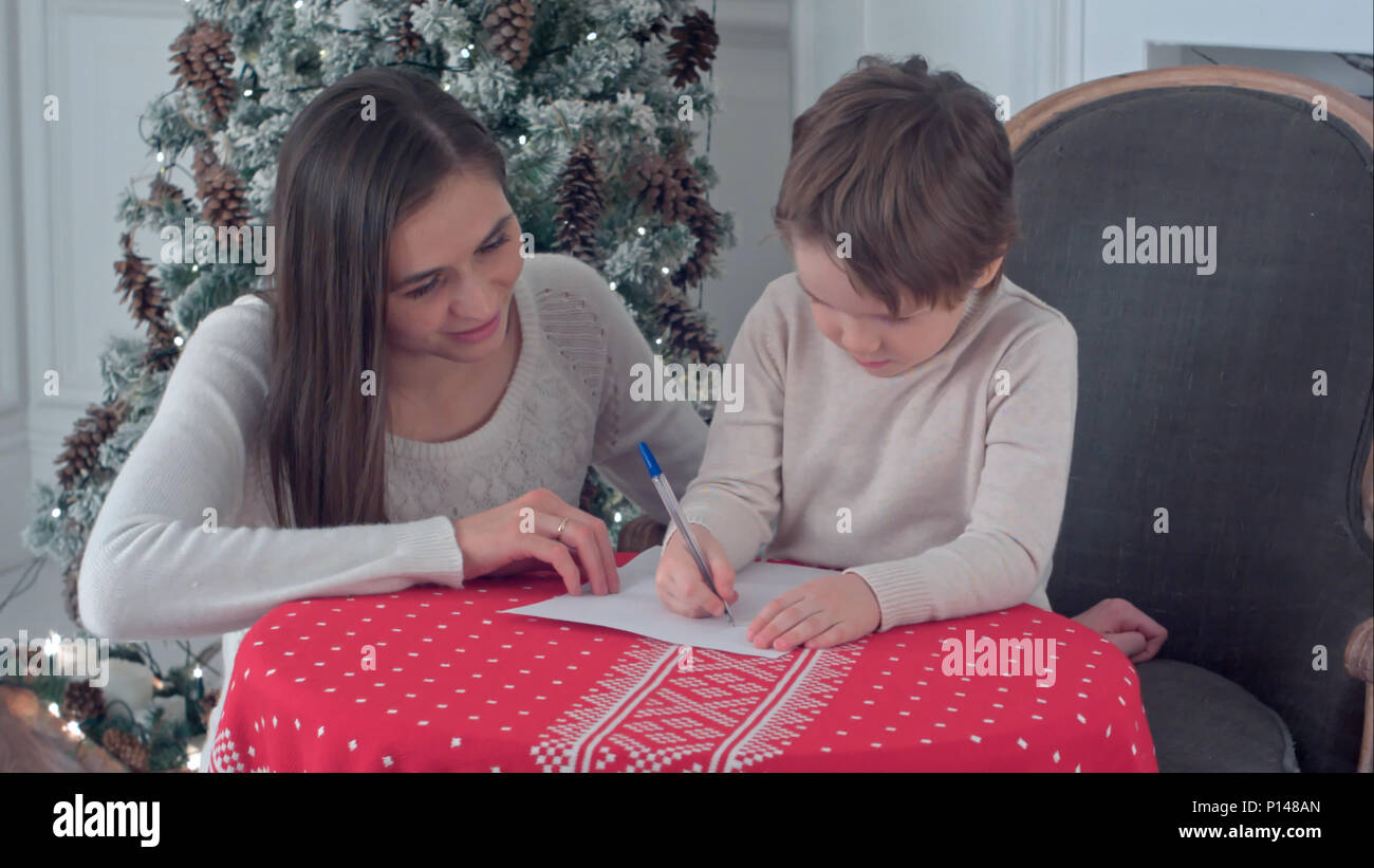 Glückliche Mutter und Sohn Brief schreiben in Santa Stockfoto